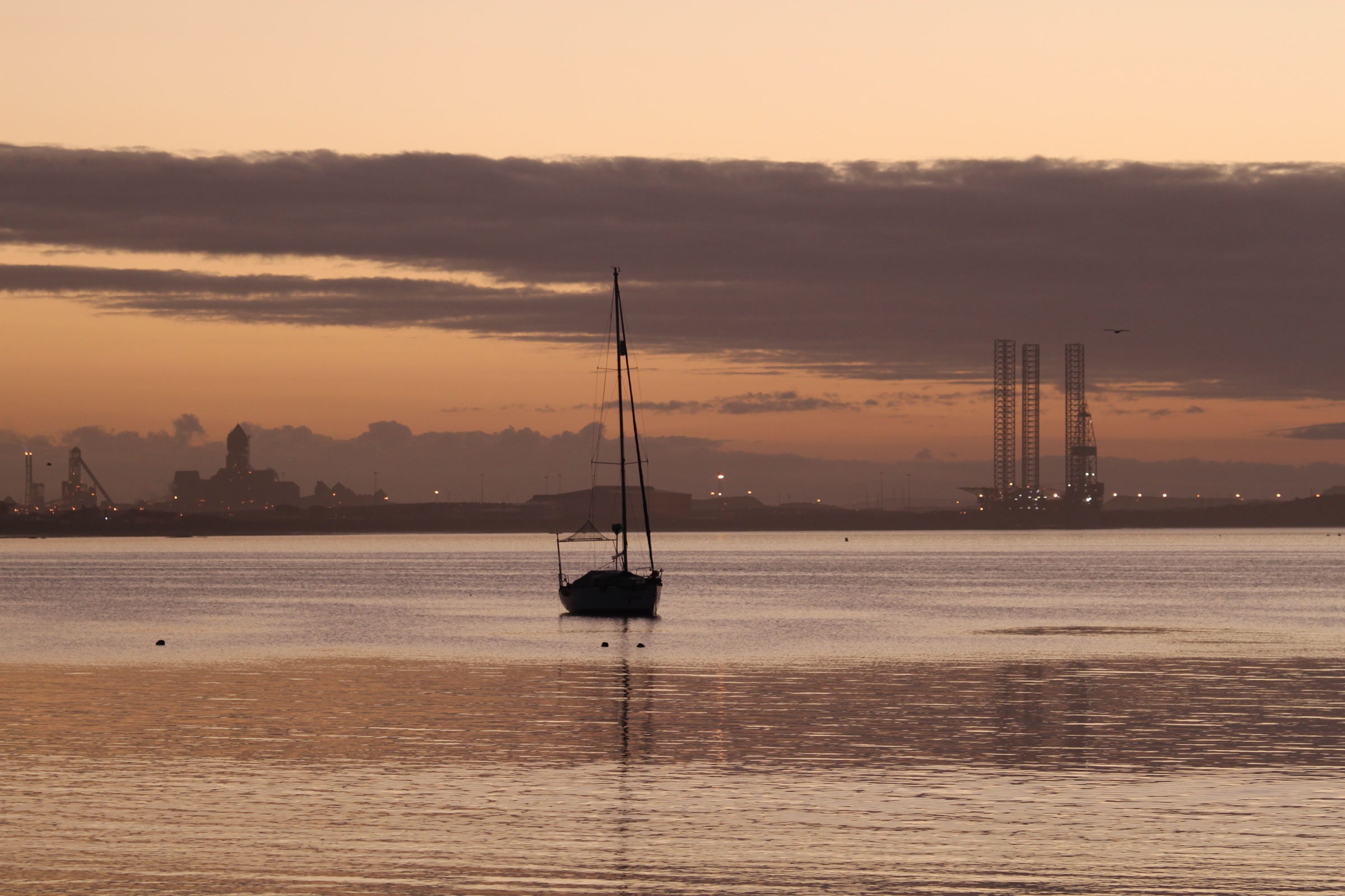 Saldanha Bay at sunset with harbour infrastructure on the horizon.