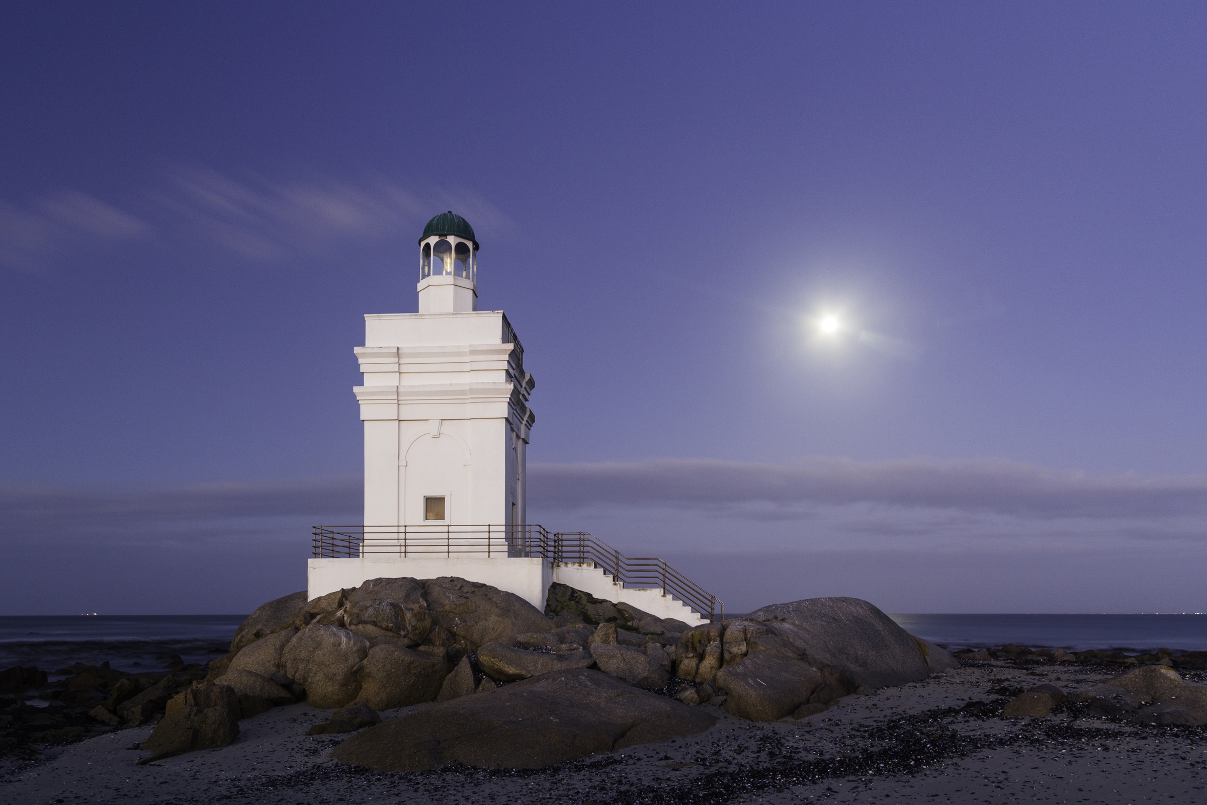 Stompneus Point lighthouse beneath a moonlit coastal sky.